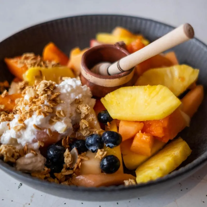 Melon with cottage cheese, honey, granola and fresh fruit