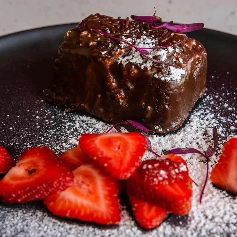 Chocolate cake with strawberry and cream filling, dusted with sugar